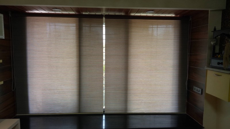 Dark pleated roller blinds in a living room